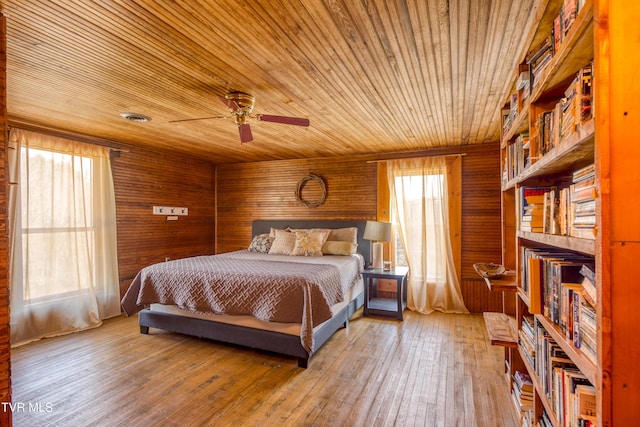bedroom with wood walls, wooden ceiling, and hardwood / wood-style floors
