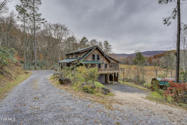 368 Ripshin Lake Rd, Roan Mountain, TN 37687 - rustic home with driveway, a garage, metal roof, a deck with mountain view, and a forest view