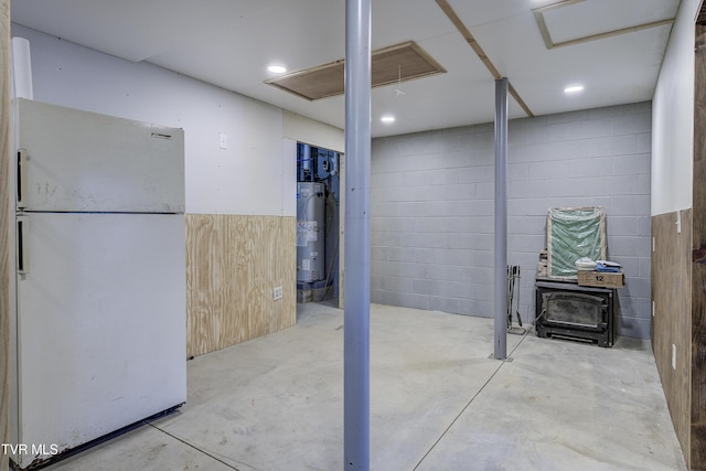 368 Ripshin Lake Rd, Roan Mountain, TN 37687 - below grade area featuring freestanding refrigerator, water heater, a wood stove, and concrete block wall
