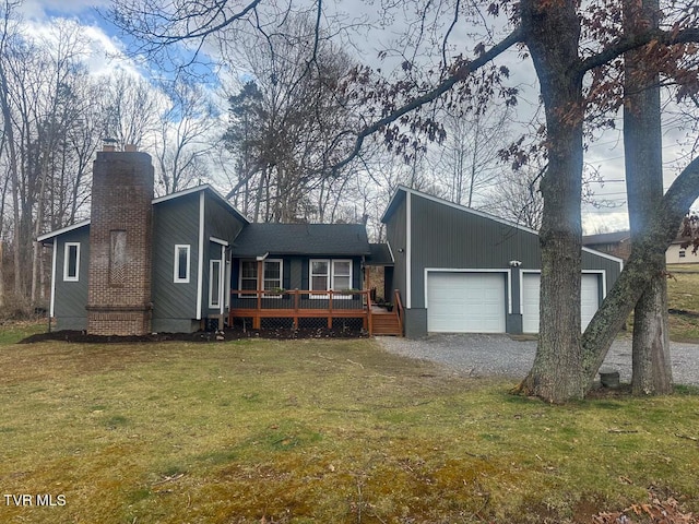 view of front of house with a front lawn, a chimney, a deck, a garage, and driveway