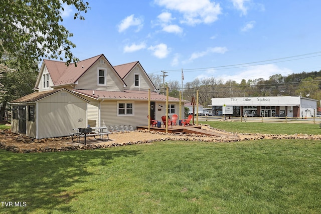 back of house with a deck and a yard
