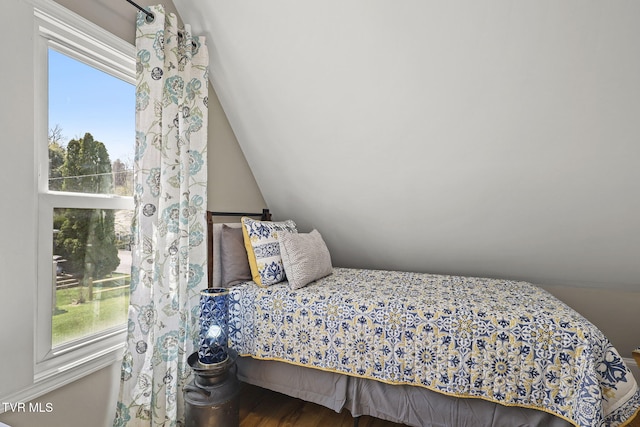 bedroom featuring multiple windows, lofted ceiling, and wood finished floors