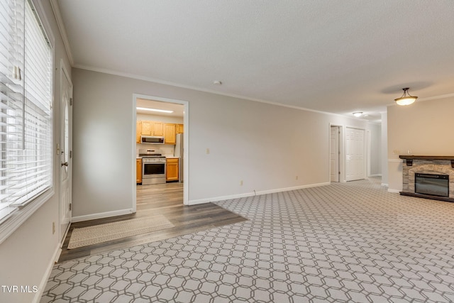 unfurnished living room featuring a fireplace, a textured ceiling, baseboards, and ornamental molding