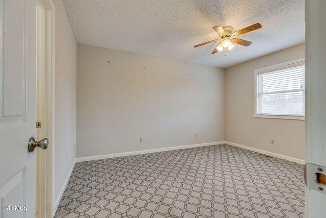empty room featuring a textured ceiling, baseboards, and a ceiling fan