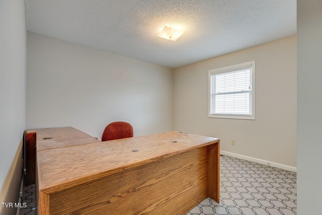 home office featuring a textured ceiling and baseboards