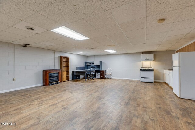 unfurnished office with concrete block wall, wood finished floors, and visible vents