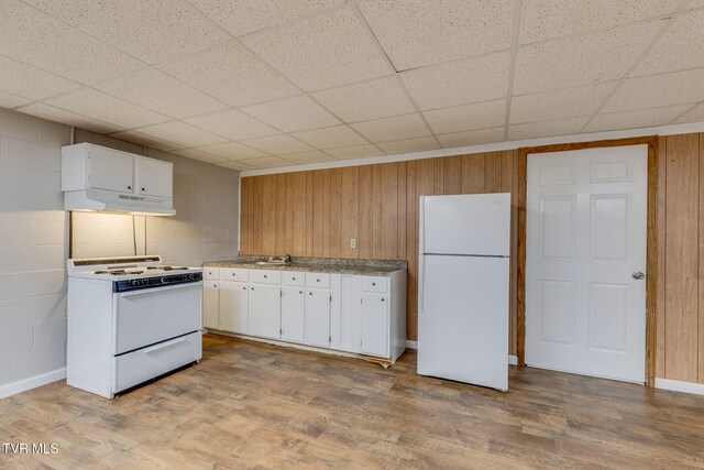 kitchen featuring under cabinet range hood, white appliances, white cabinetry, and wood finished floors