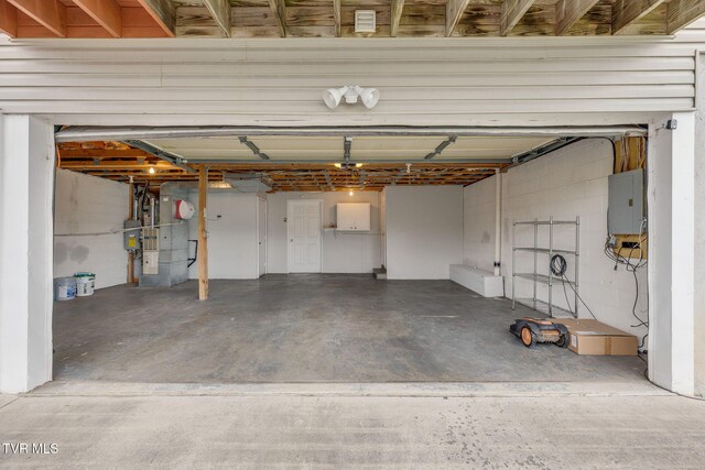 garage with electric panel and concrete block wall