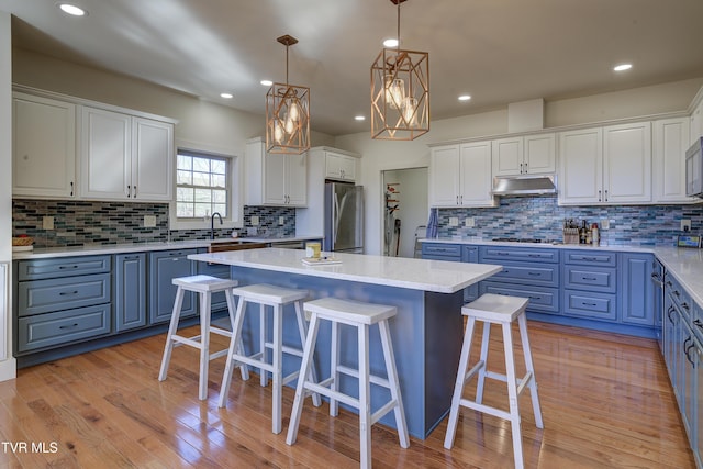 137 Unaka View Rd, Johnson City, TN 37601 - kitchen with blue cabinets, stainless steel appliances, under cabinet range hood, and white cabinetry