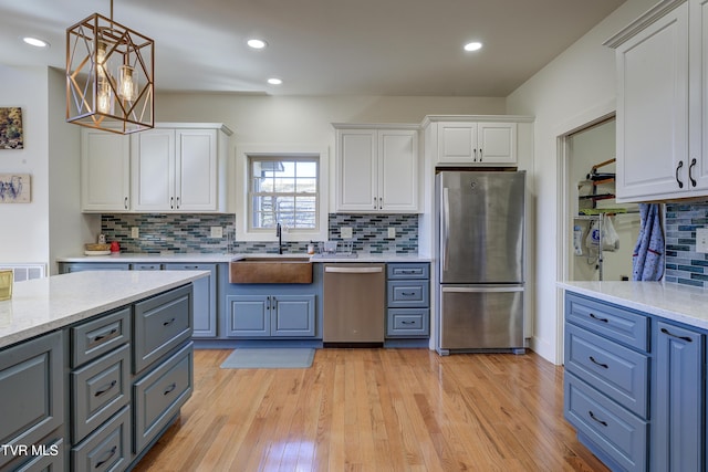 137 Unaka View Rd, Johnson City, TN 37601 - kitchen featuring light wood-style flooring, a sink, stainless steel appliances, white cabinets, and pendant lighting