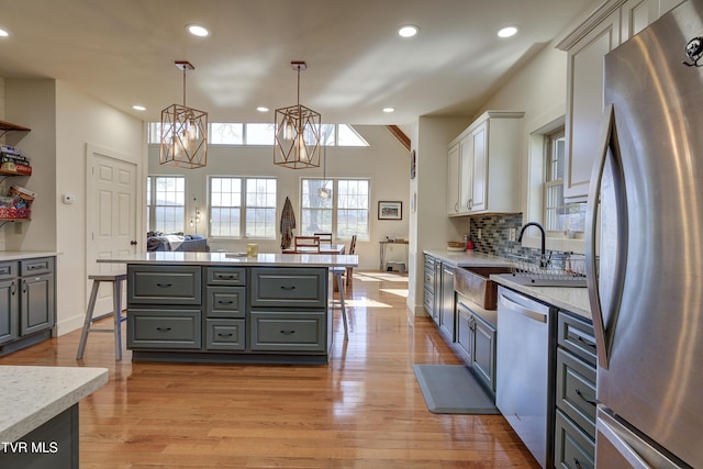 137 Unaka View Rd, Johnson City, TN 37601 - kitchen with light wood-type flooring, gray cabinetry, a sink, stainless steel appliances, and an inviting chandelier