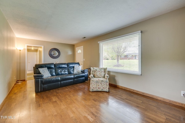 living area featuring light wood-style floors, visible vents, and baseboards