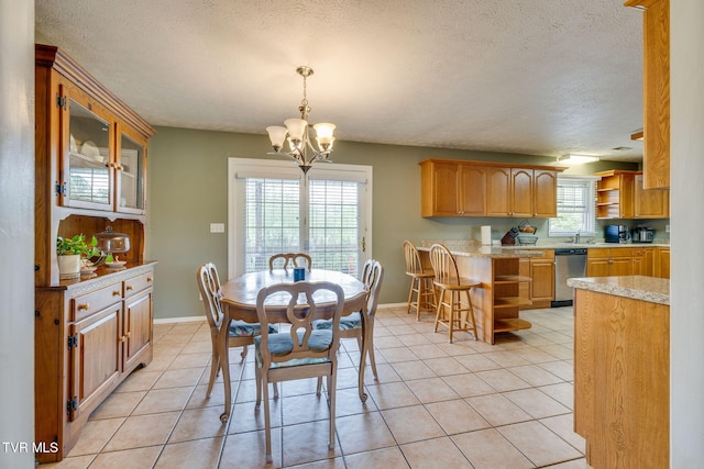 dining space with baseboards, a textured ceiling, a chandelier, and light tile patterned flooring