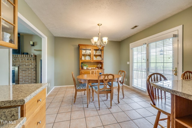 dining space with baseboards, a chandelier, and light tile patterned flooring