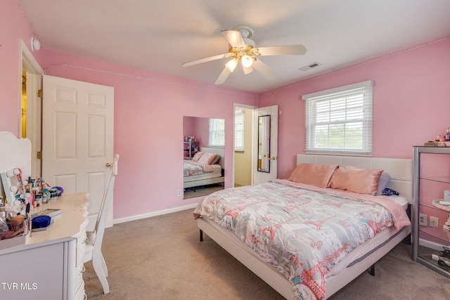 bedroom with ceiling fan, visible vents, and light colored carpet