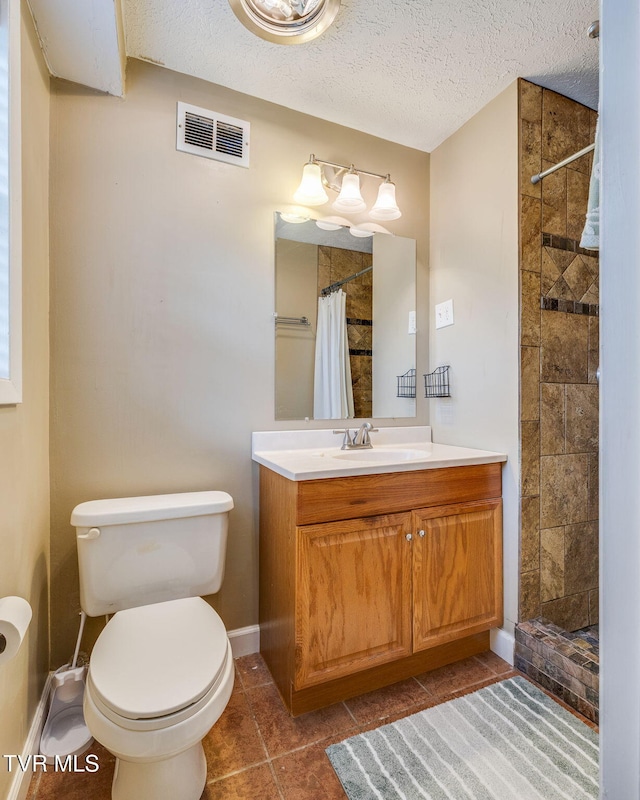 full bath with a textured ceiling, vanity, a tile shower, toilet, and visible vents