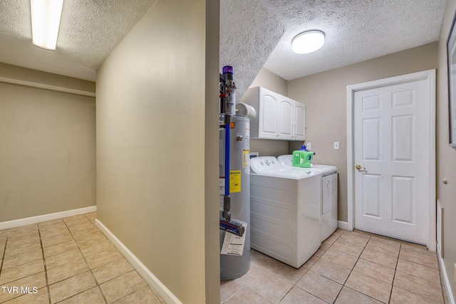 laundry room with washing machine and dryer, a textured ceiling, cabinet space, and light tile patterned flooring