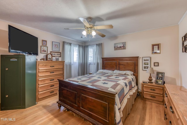 bedroom featuring light wood-style flooring, crown molding, and ceiling fan
