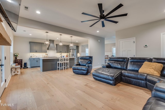 living room featuring visible vents, a ceiling fan, recessed lighting, light wood finished floors, and baseboards
