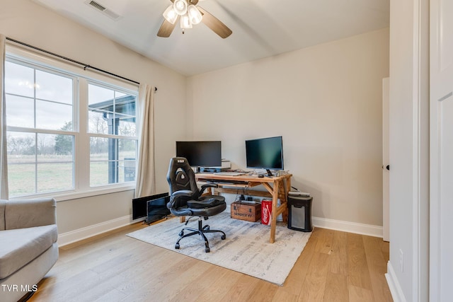office space with ceiling fan, visible vents, baseboards, and wood finished floors