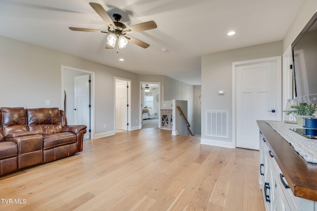 living room with light wood-style flooring, recessed lighting, a ceiling fan, and visible vents