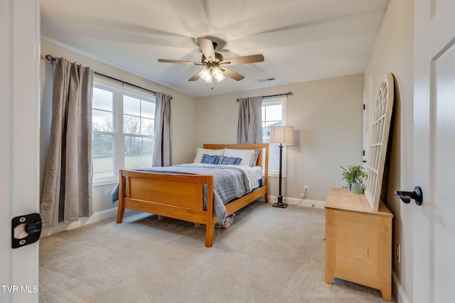 bedroom featuring ceiling fan, visible vents, baseboards, and light carpet