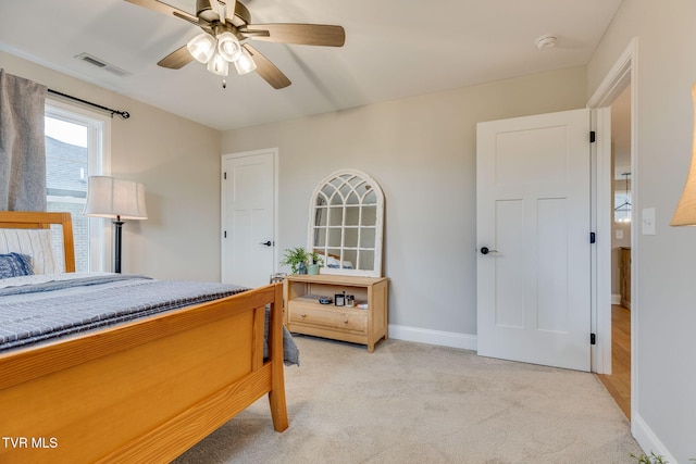 bedroom featuring visible vents, light carpet, baseboards, and ceiling fan