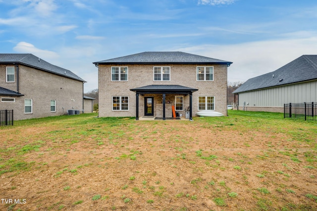 rear view of property featuring fence, brick siding, and a patio area