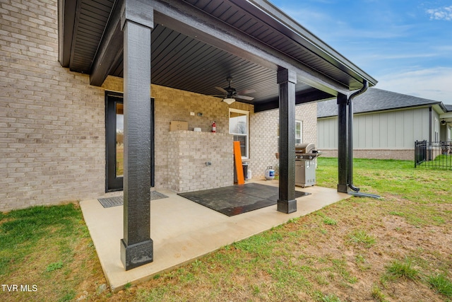 view of patio featuring area for grilling, ceiling fan, and fence
