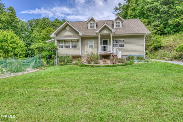 new england style home with roof with shingles and a front yard