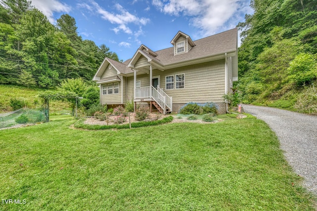 view of front of home featuring a shingled roof and a front yard