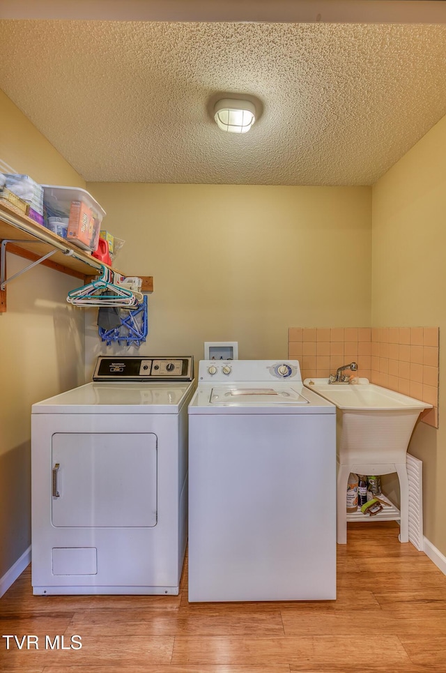 laundry area with light wood-style floors, washer and clothes dryer, and laundry area