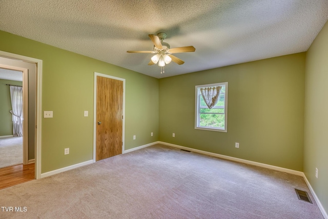 unfurnished room featuring visible vents, baseboards, a ceiling fan, and carpet flooring