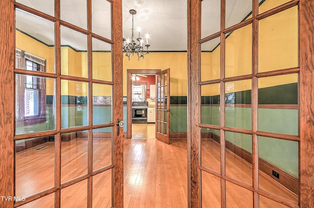415 Fairgrounds Rd, Greeneville, TN 37745 - hallway featuring french doors, a textured ceiling, an inviting chandelier, and wood-type flooring