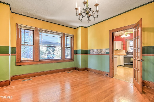 415 Fairgrounds Rd, Greeneville, TN 37745 - spare room with visible vents, a healthy amount of sunlight, a notable chandelier, a textured ceiling, and wood-type flooring
