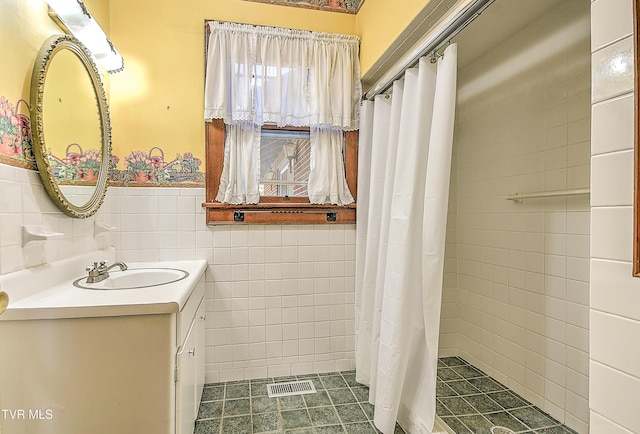 415 Fairgrounds Rd, Greeneville, TN 37745 - full bath featuring vanity, visible vents, a wainscoted wall, tiled shower, and tile walls