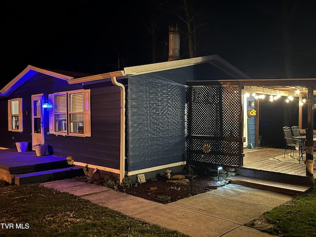 property exterior at twilight featuring a wooden deck