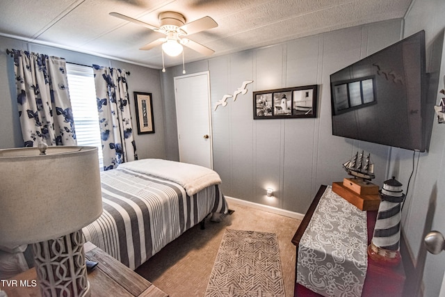 bedroom featuring a decorative wall and ceiling fan
