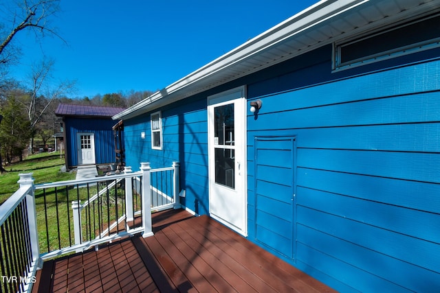 wooden deck featuring a lawn