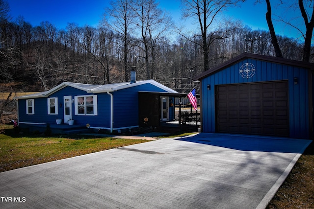 view of side of home with a garage, a lawn, and concrete driveway