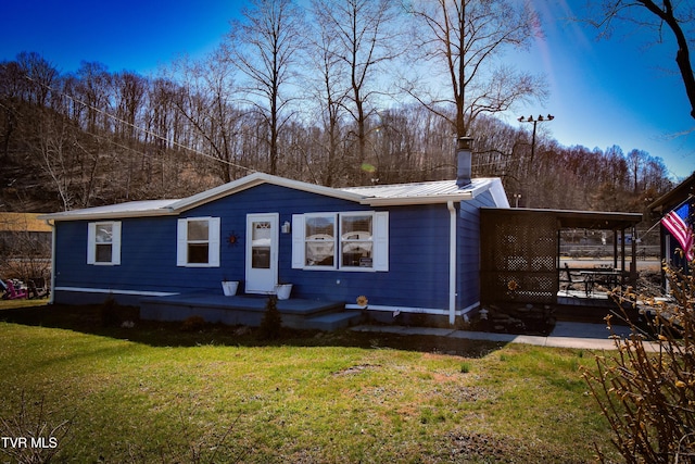 view of front of property with a front lawn and metal roof
