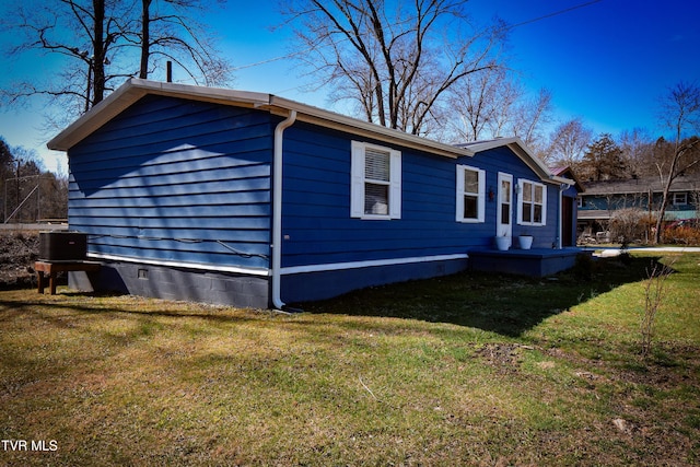 view of side of home featuring crawl space and a yard