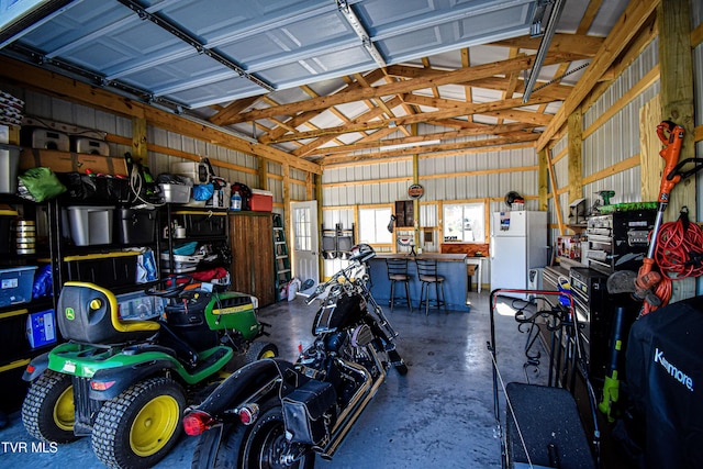 garage with metal wall and freestanding refrigerator
