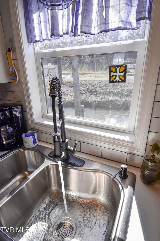 room details featuring decorative backsplash and a sink