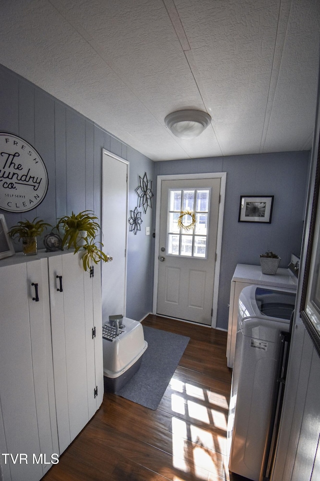 interior space featuring dark wood finished floors, laundry area, washer and dryer, and a textured ceiling