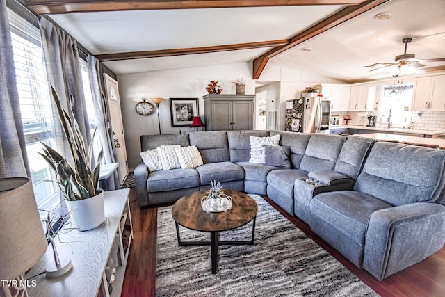 living room featuring vaulted ceiling with beams, dark wood-type flooring, and ceiling fan