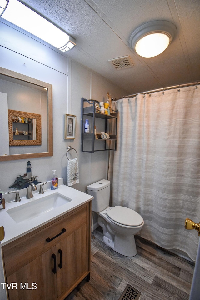 full bath with visible vents, toilet, vaulted ceiling, wood finished floors, and vanity