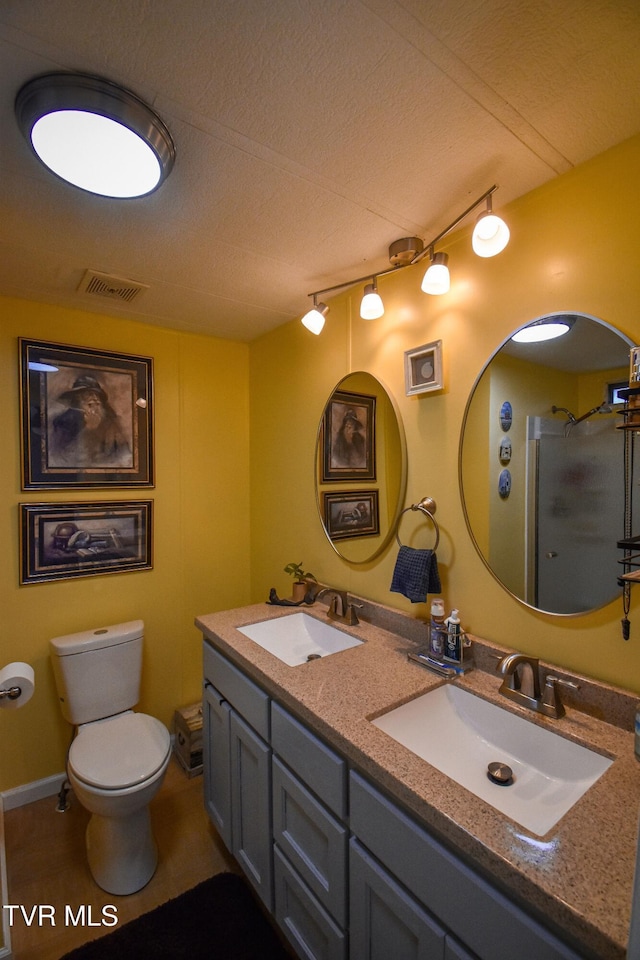 full bathroom featuring a sink, visible vents, toilet, and double vanity