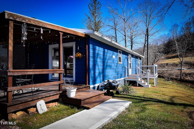 exterior space featuring a wooden deck and a front yard