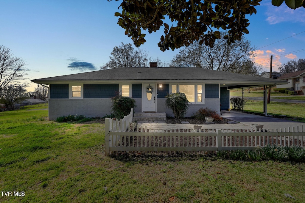 1744 Audie St, Kingsport, TN 37665 - single story home featuring a fenced front yard, a lawn, concrete block siding, a carport, and driveway